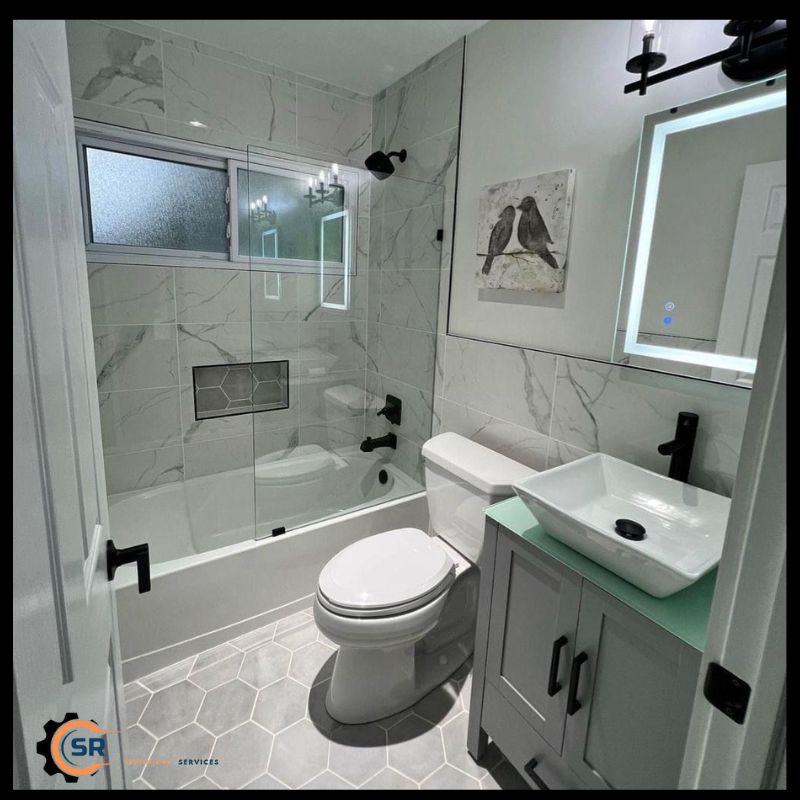 Technician installing energy-efficient lighting in renovated residential bathroom